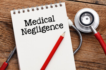 Medical negligence words in an office notebook next to a stethoscope.