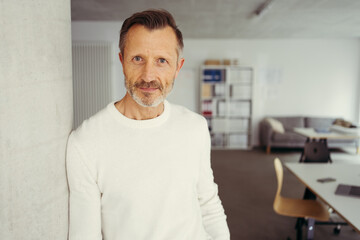 Relaxed stylish successful businessman relaxing in the office looking into the camera