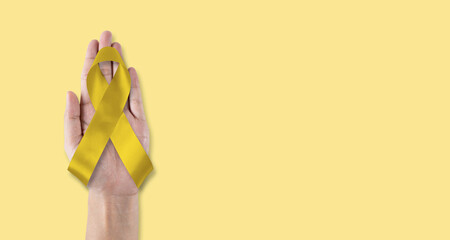 Childhood cancer awareness with gold ribbon isolated on white background with clipping path. Golden...