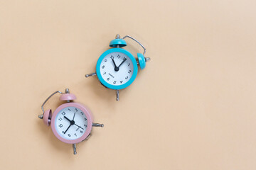 blue and pink alarm clock on beige background