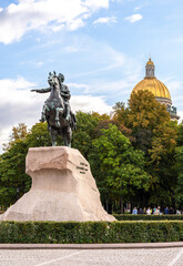 Fototapeta premium St. Petersburg, Russia - september 2022: Monument to Peter the Great (First) on Senate square and the dome of St. Isaac's Cathedral