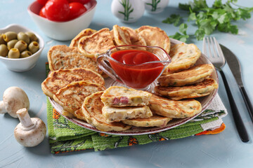 Pancakes pizza with ham, cheese, mushrooms and garlic, served for breakfast with tomatoes sauce