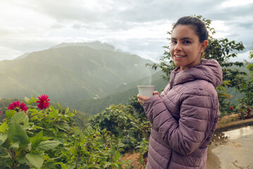 Woman smiling having a cup of coffee on the colombians mountains