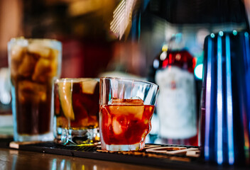 hands of a bartender with black gloves making cocktail on a bar counter.