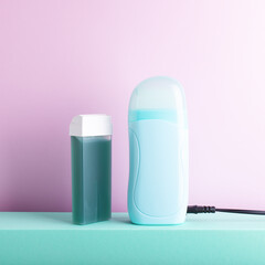 Front view of depilatory electric heater and hair removal wax cartridge standing on decorative...