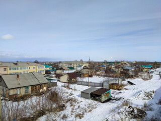 Kamen-na-Obi, Altai, Russia - March 25, 2022: Top view of houses and metal garages in the Russian outback. Spring day
