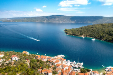 Motorboot fährt in der Bucht vor dem Fischerort Valun auf der Insel Cres, Kroatien