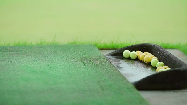 Golfer hitting a golf ball with an iron club on a driving range