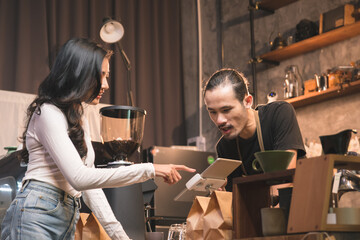 Asian baristas are chatting and taking coffee orders from customers in a coffee shop, Coffee and barista concept