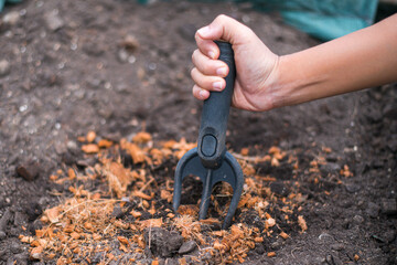 hand holding shoveling fork for loosening soil