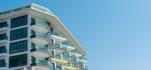 Modern apartment building with balconies isolated on sky background for ad text.