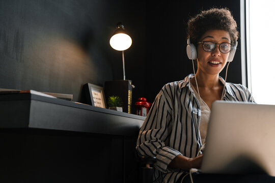 Young Black Woman In Headphones Working With Laptop