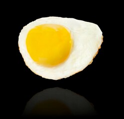 Fried egg levitation isolated on black background.