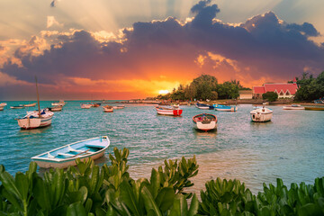Beautiful landscape on Mauritius Island with traditional boats and beach illuminated at sunrise, in...