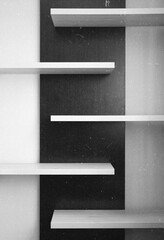 empty shelf on a wall black and white with dust 