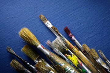 Used painter brushes flat lay on a blue background close-up - 536086174