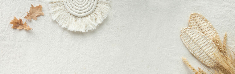 Off white Autumn panoramic banner. Monochromatic textile background with dry leaves, straw fans,...
