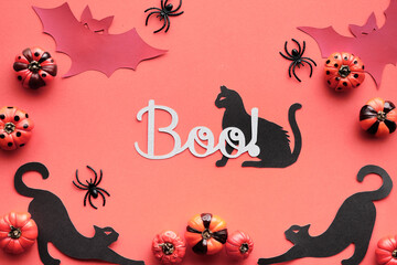Salmon pink, orange Halloween background. Silhouettes of black cats, paper bats and black spiders....