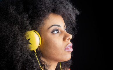 Concentrated ethnic woman listening to music with headphones