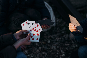 Crop hands of three children playing cards in a train track