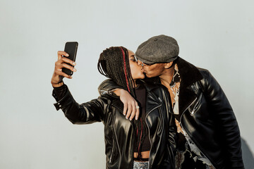 Black couple kissing and taking selfie