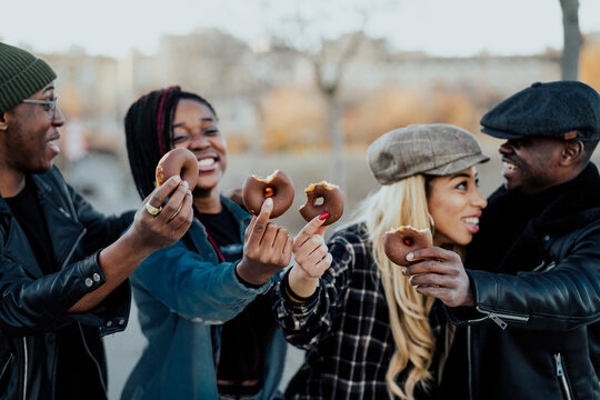 Black Friends Eating Donuts On Street