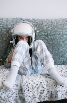 Kid lying on couch and playing with a video game console at home