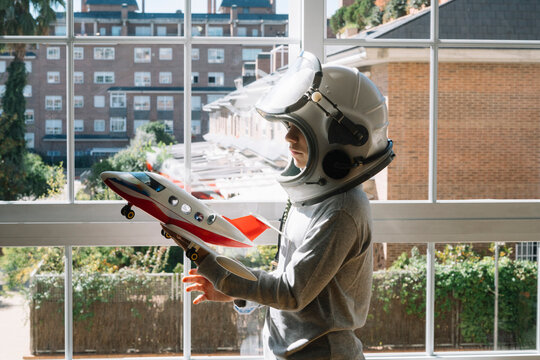 Adorable kid with helmet playing with a toy plane