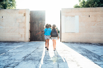 African American girl walking with friend on street in bright da