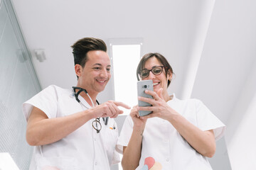 Couple of doctors walking along hospital corridor