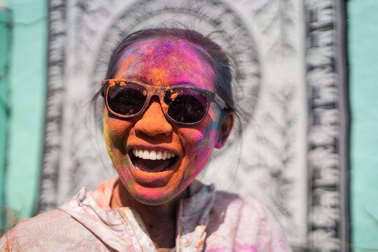 Positive woman with face in Holi powder