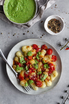 Plate of yummy gnocchi near condiments