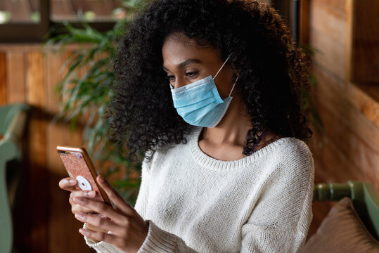 Black Woman In Mask On Smartphone In House