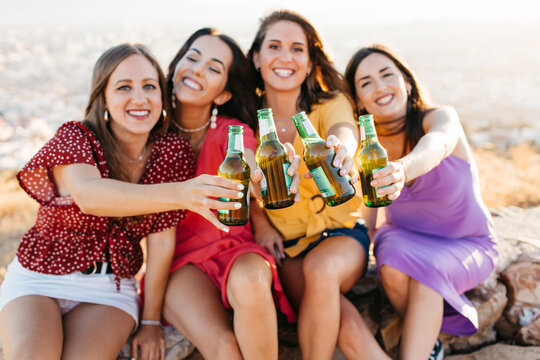 Happy friends clinking bottles of beer