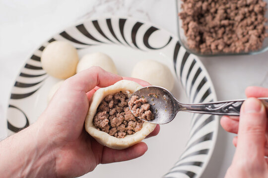 Woman cooking bollos pelones with ground meat