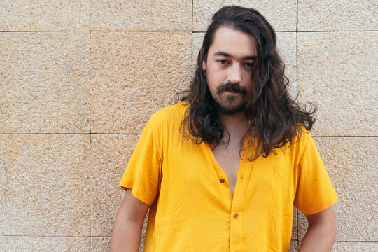 Portrait os stylish man with long hair in city