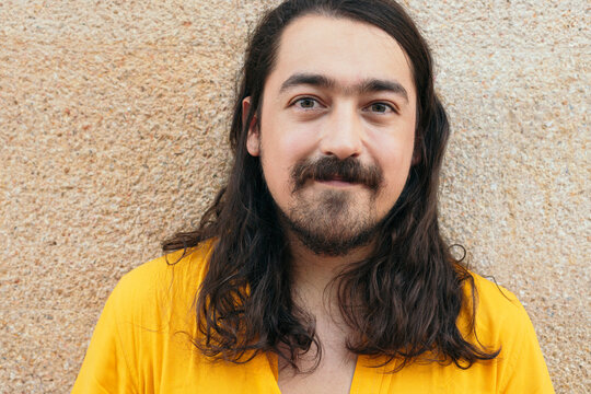 Portrait os stylish man with long hair in city