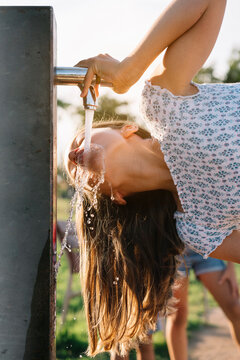 Girl drinking water from standpipe