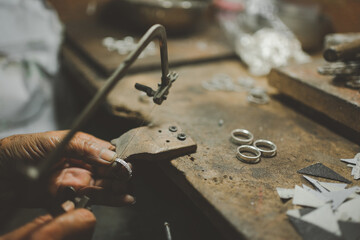 Jeweler at work in jewelry. Desktop for craft jewelry making with professional tools. Close up view...