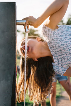 Girl drinking water from standpipe