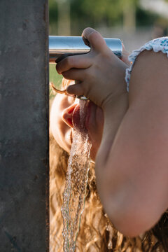 Girl drinking water from standpipe