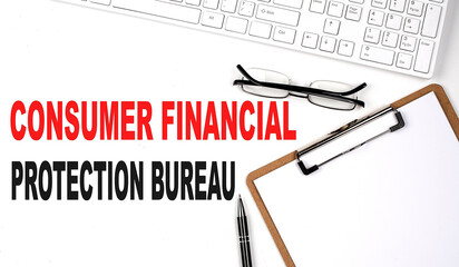 CONSUMER FINANCIAL PROTECTION BUREAU text written on the white background with keyboard, paper...