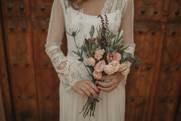 Charming attractive young woman in dress with bouquet of flowers
