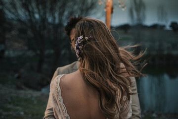 Anonymous bride hugging groom near lake