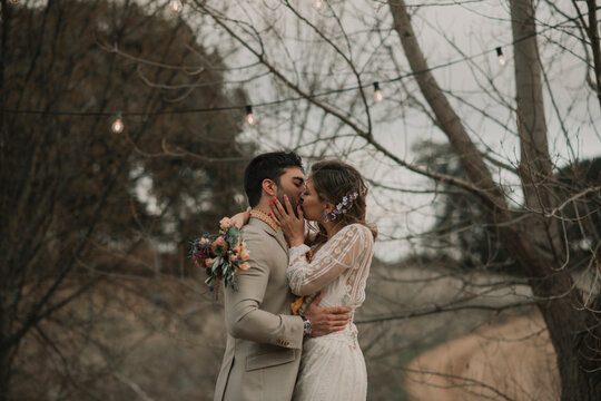 Man kissing with woman holding bouquet