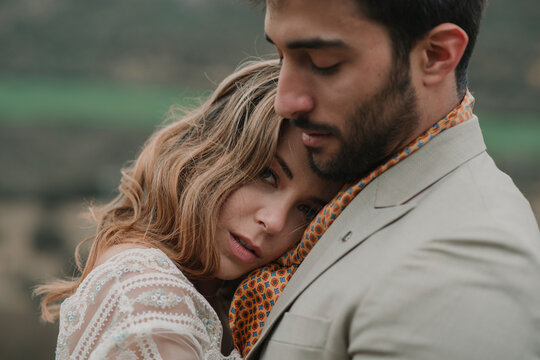 Man hugging with woman on hill and view on valley
