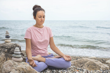 Fototapeta na wymiar Relaxed yoga woman in lotus posture mudra harmony balance meditation at sea beach nature landscape