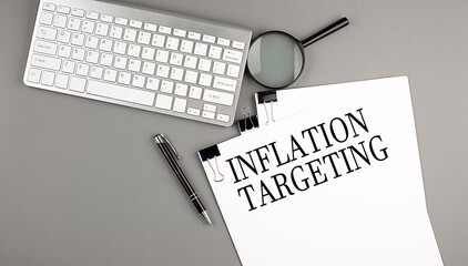 INFLATION TARGETING text on paper with keyboard, magnifier and pen. Business concept