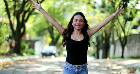Excited Brazilian woman celebrating jumping with joy and happiness