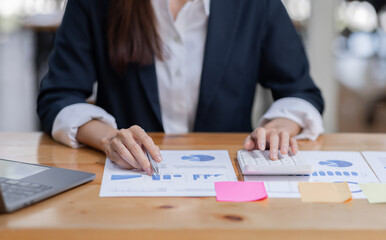 Cheerful female businesswoman entrepreneur professional working on laptop while sitting in workplace office desk, business asian woman do Documents, tax, report analysis Savings, finances economy.